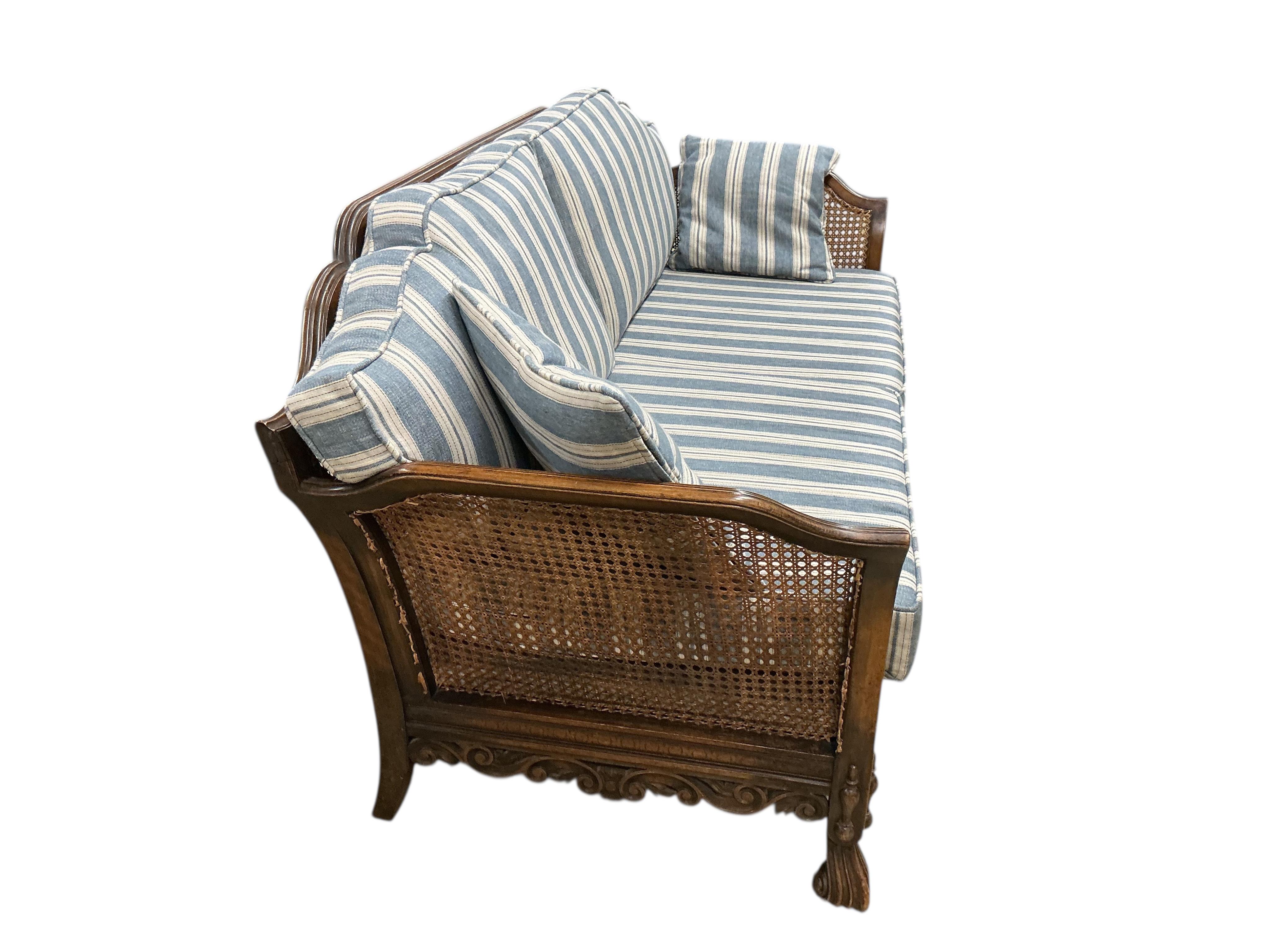 An early 20th century William & Mary style oak bergere settee, with loose cushion seat and back, width 172cm, depth 71cm, height 80cm